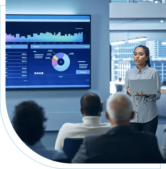 A presenter explains data charts to a seated audience in a modern conference room.