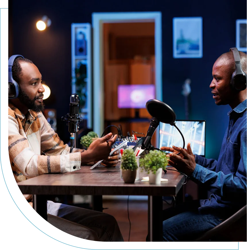 Two men having a podcast conversation with microphones at a table.