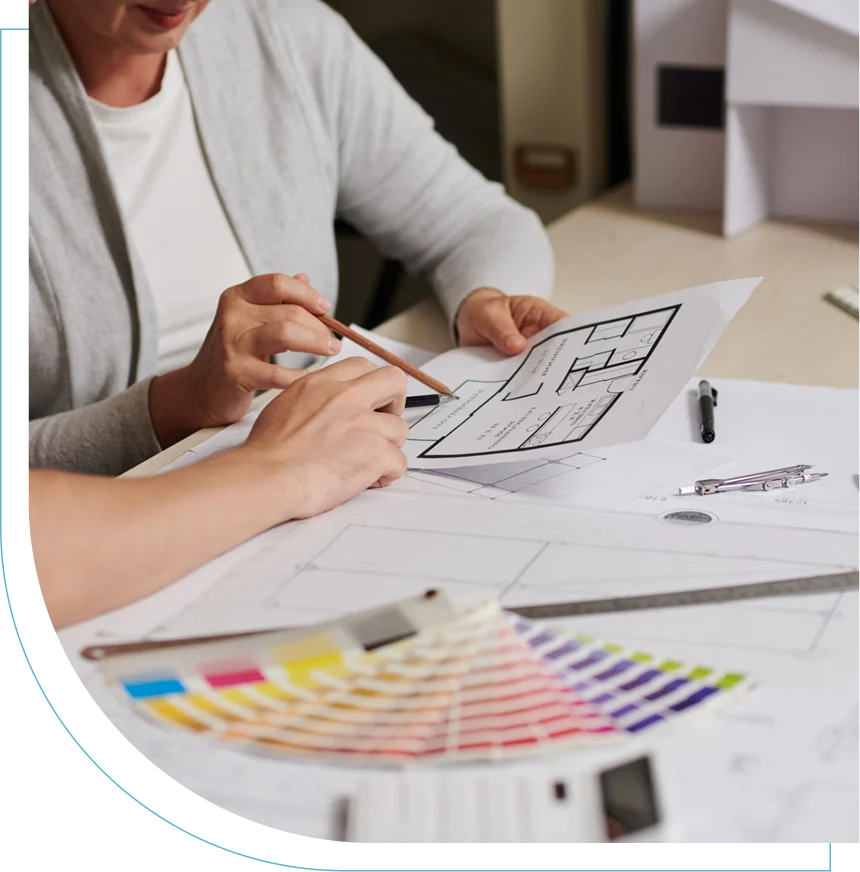 Person sketching interior design plans with color swatches nearby.