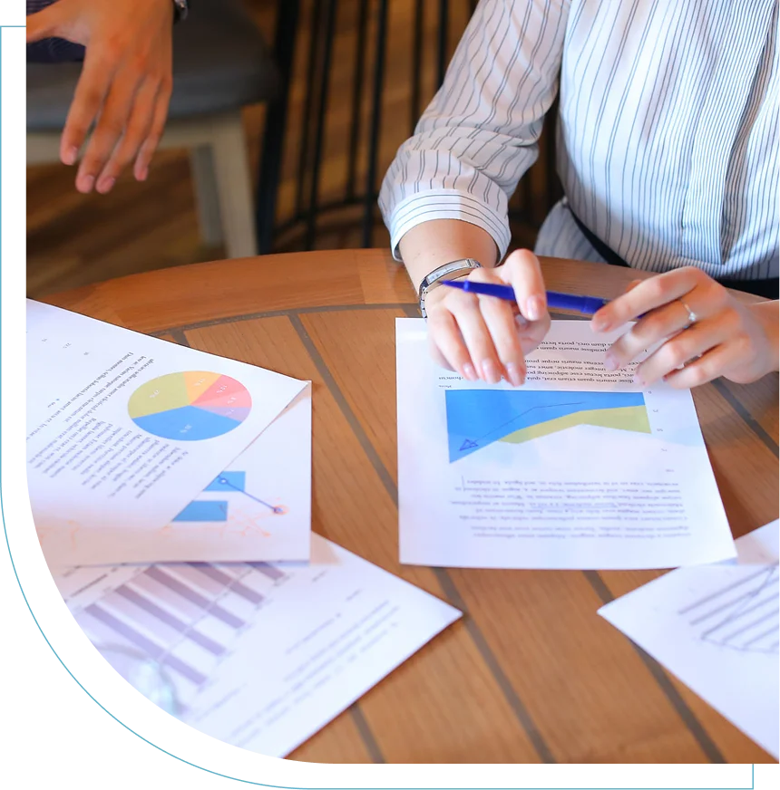 Person analyzing financial charts and graphs at a table.
