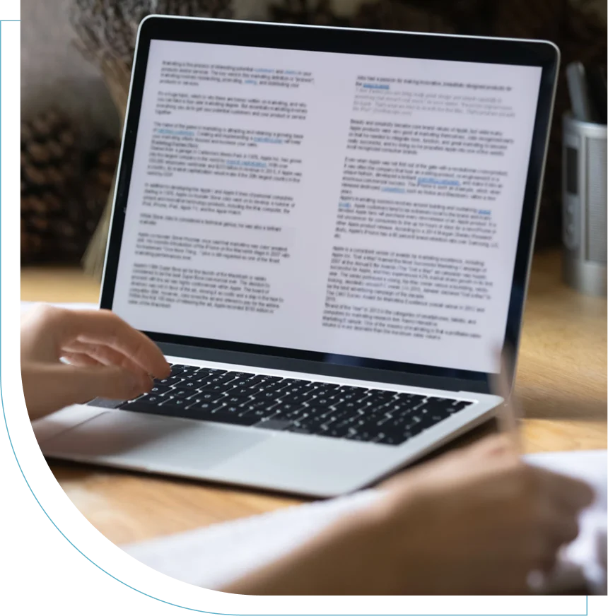 Person reading detailed text on a laptop screen indoors.